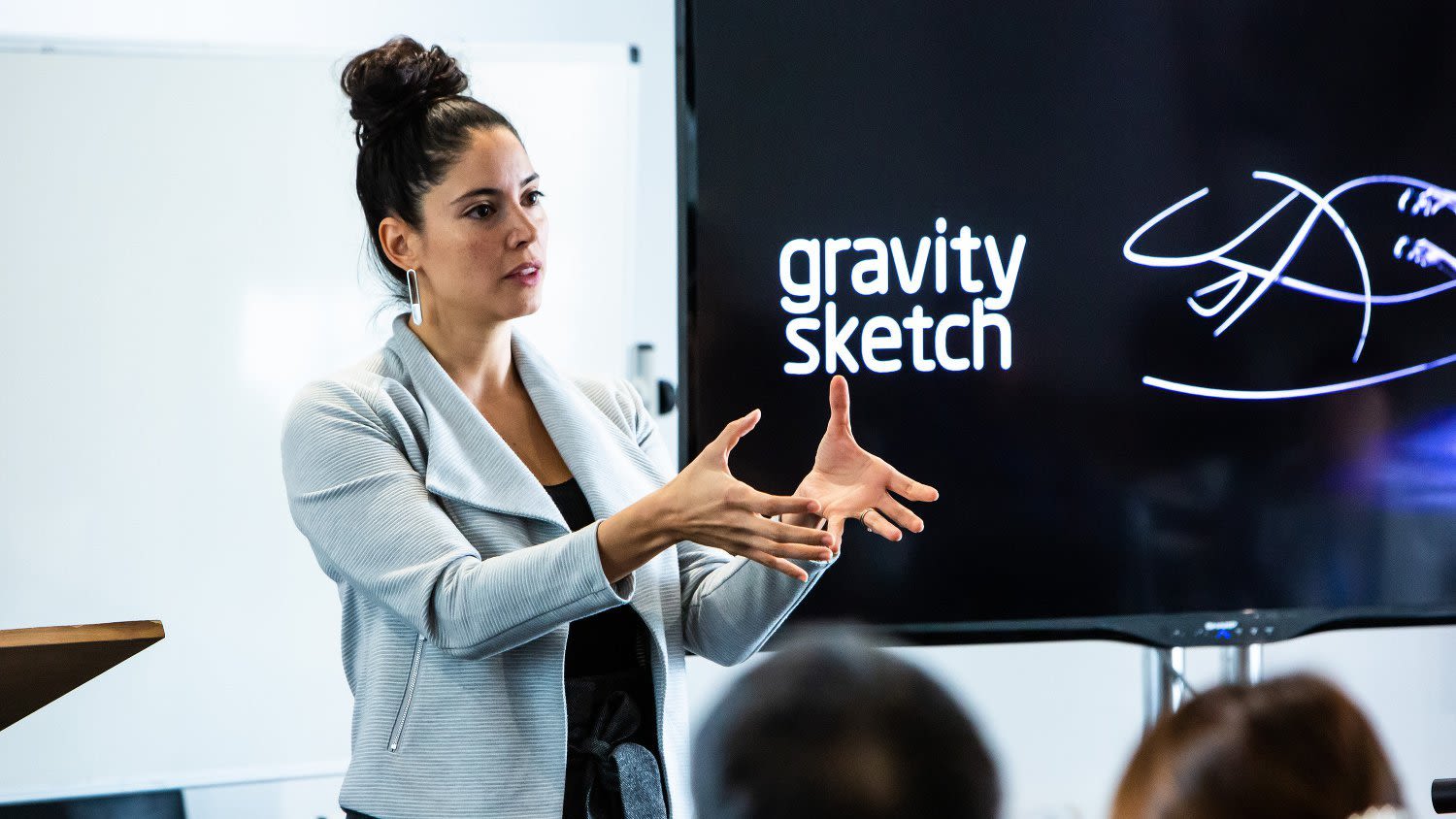 The founder of gravity sketch gives a talk in front of a screen with the words 'gravity sketch'